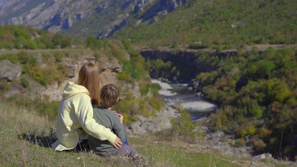 A Handheld Shot of a Young Woman and Her Son That are Visiting the Moracica River Canyon in