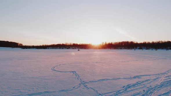 Winter Landscape View of Frozen Lake with Camping on Ice at Sunset