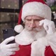 Closeup Portrait of a Brooding Santa Reads the Message on His Smartphone Through His Lowered - VideoHive Item for Sale