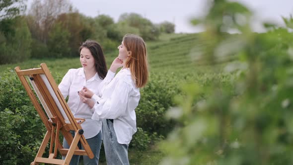 Elegant and Beautiful Girls Painting in a Field