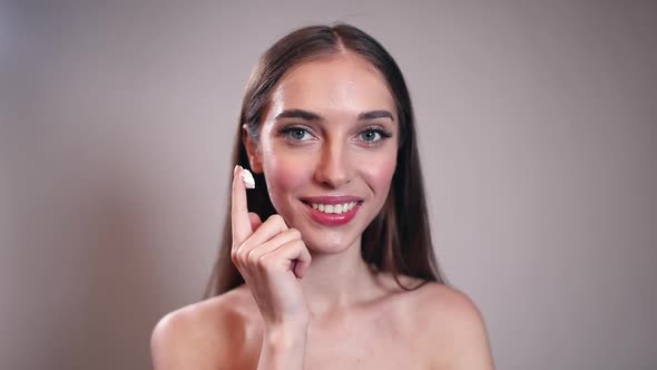 Girl Applying Cream on Her Face