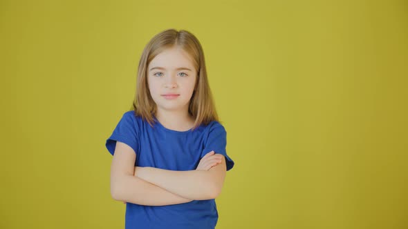 Upset Child with Hands Crossed on Yellow Background in Studio