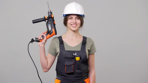 Portrait of Woman Specialist Builder in Helmet and Jumpsuit Working on Manufacture or Factory and