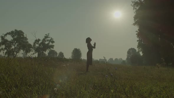 Faithful Attractive Female Saying Prayers to God in Summer Nature at Dawn alt