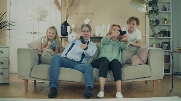 Grandmother, Grandfather and Their Grandkids Are Playing Videogames