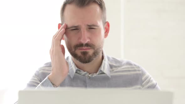 Close Up of Man with Headache Using Laptop