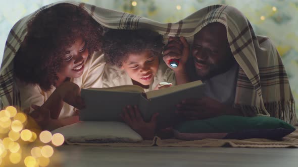 African American Family Reading Book on Bed