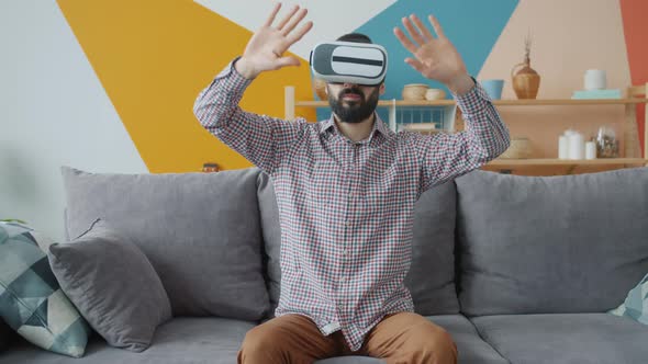 Young Brunet Man Enjoying Game in Vr Goggles Having Fun at Home with Modern Device