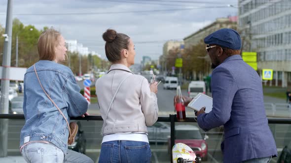 Friends standing on the street with food and drinks