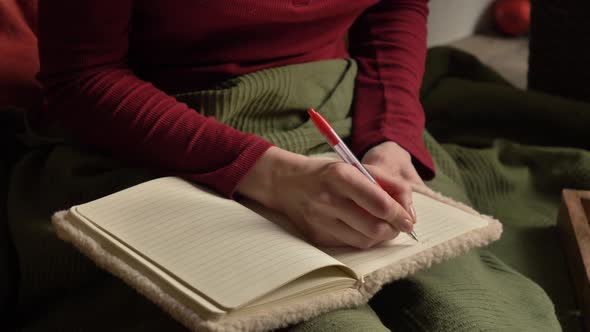Woman write notes in notebook in bed