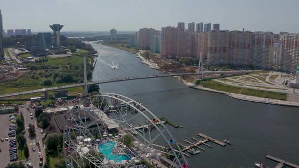 a Ferris Wheel on the River Bank with a Swimming Pool and a Beautiful Summer Landscape