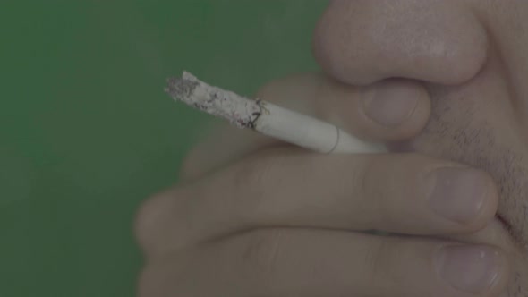 Cigarette in the Mouth of a Smoker. Close-up. Chroma Key. Green Background.