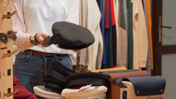 Attractive Woman Checking Out a Hat, Shopping at Clothing Store