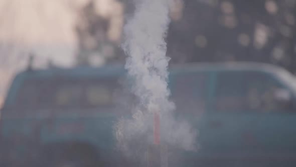 Smoke burning down a tube and a firework goes off in slow motion.