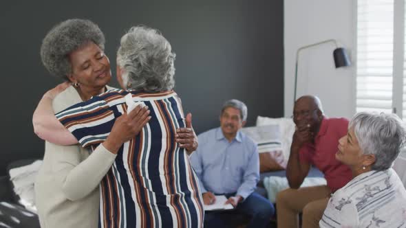 Diverse group of senior friends giving support to african american female friend on meeting
