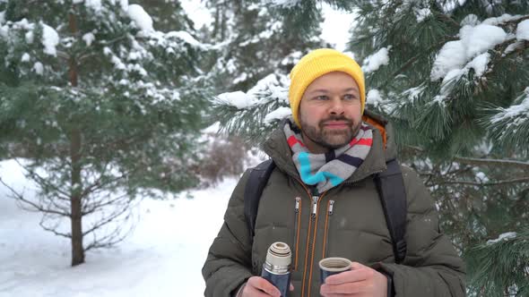 Man drinking hot tea in the forest