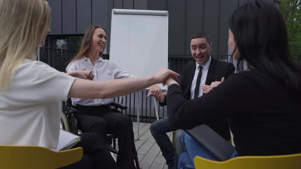 Group of Young Cheerful Business People Holding Hands Rejoicing Strategy Success Meeting Outdoors