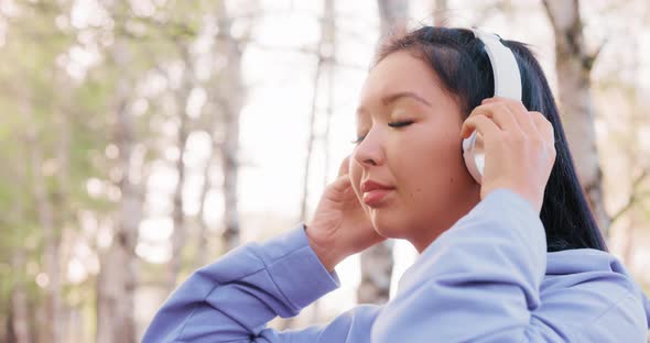 Asian Woman Listening to Music with Headphones