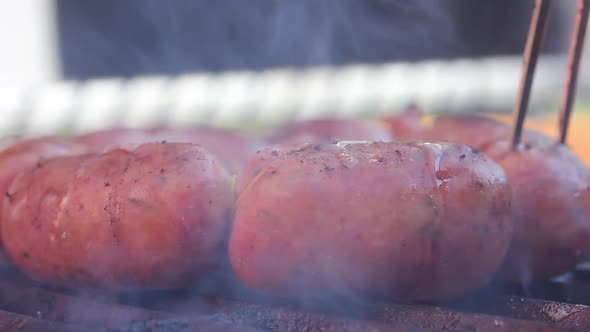 Pork Sausages grilling on a Portable BBQ.