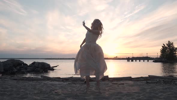 Beautiful Girl Dancing at Sunset on the Shore