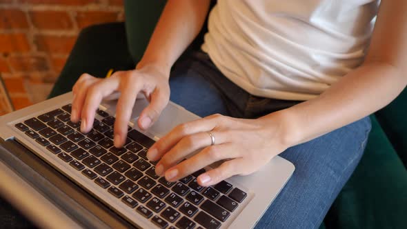 Woman Works Remotely in Cafe with Red Brick Walls