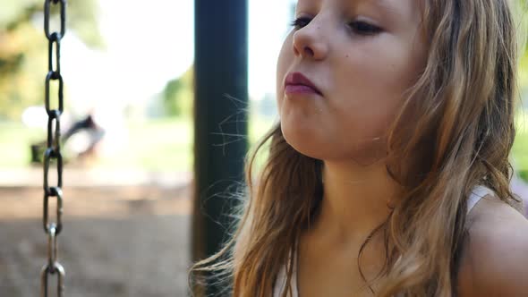 Close-up of blonde girl as she listens to playground conversation