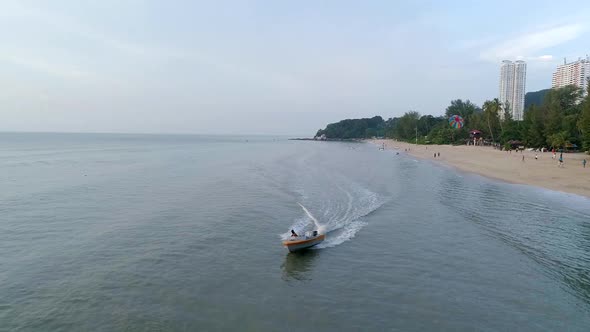 A slowmo shot of a boat driver preparing a landing of a Parasailer in Penang, Malaysia.