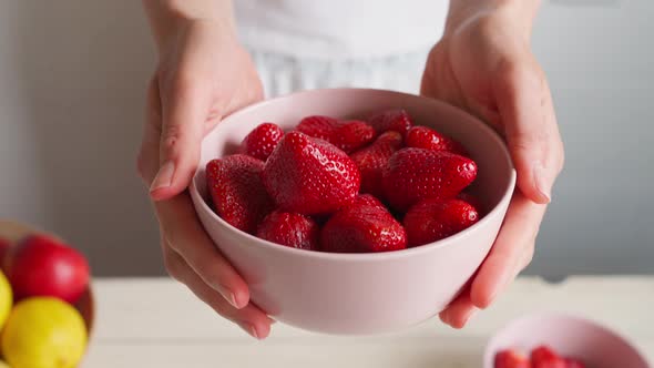 Camera Following Woman's Hands with Bowl with Strawberries