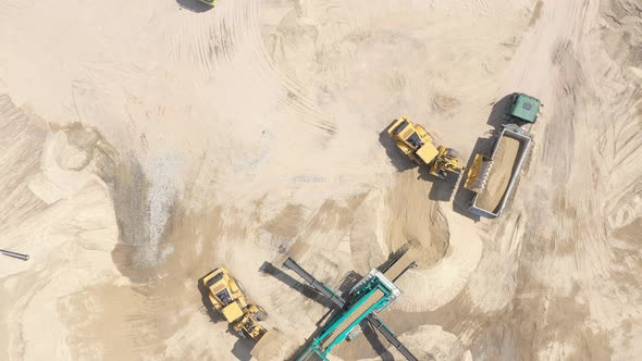 Heavy equipment machine wheel loader on sand mine. bulldozer loading sand. Aerial view