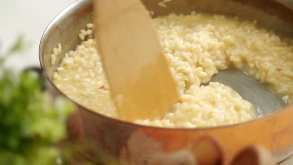 Unrecognizable cook preparing risotto in pan