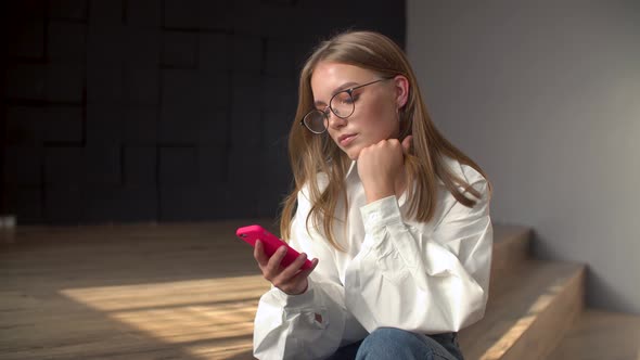 Young Woman Using Smartphone in a Livingroom