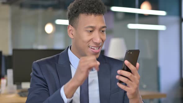 Portrait of Cheerful Young Businessman Celebrating on Smartphone 