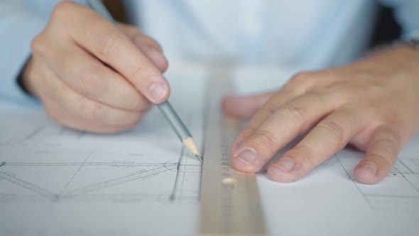 Engineer's hands drawing a building plan