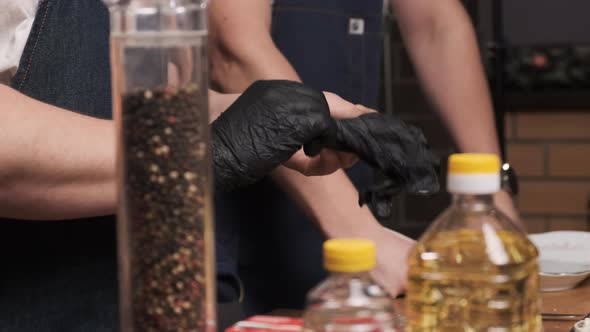 Chef in Restaurant Wears Black Latex Gloves to Prepare Gourmet Dish for His Guests