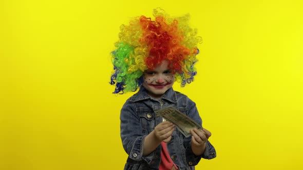 Little Child Girl Clown in Colorful Wig. Money Dollar Cash Banknotes Income Falls From Above