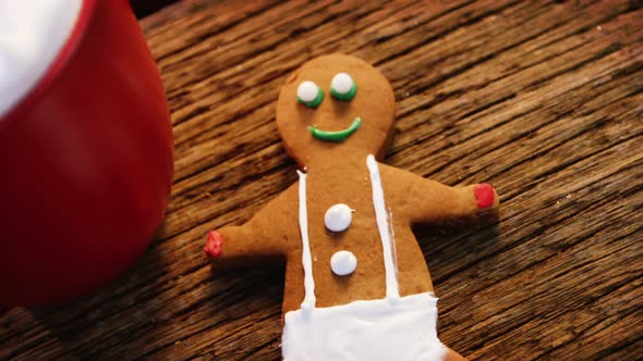 Coffee mug with gingerbread and decoration on a plank