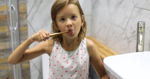 Little Girl Brushing Teeth in the Bathroom at Home