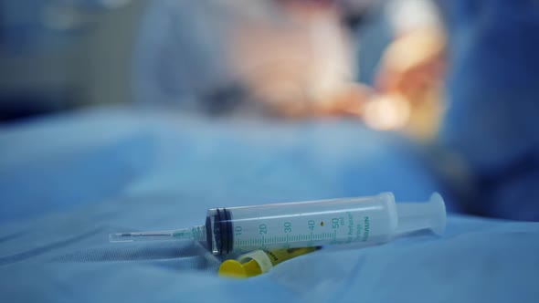 Instrumental Surgical In Operating Room. Plastic syringe on the table.