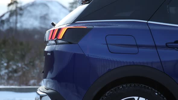 Rear lights and fuel filler neck. Side of the blue crossover. SUV at the street