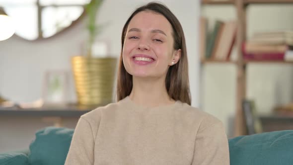 Portrait of Young Woman Smiling at Camera at Home