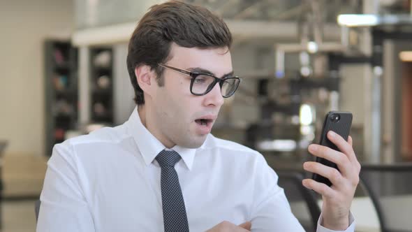 Businessman in Shock while Using Smartphone