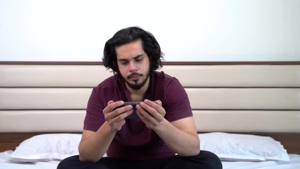 Indian man watching video on mobile phone