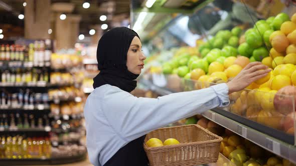 Muslim Woman Arrange the Fruits at the Supermarket