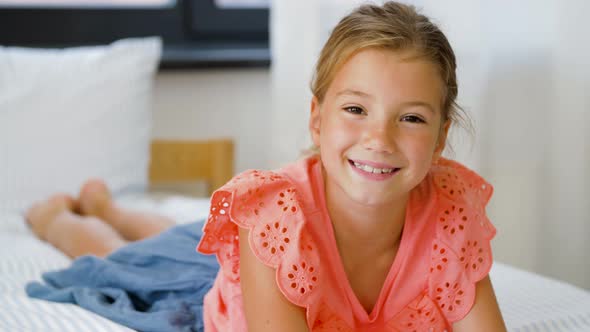 Happy Smiling Beautiful Girl Lying on Bed at Home