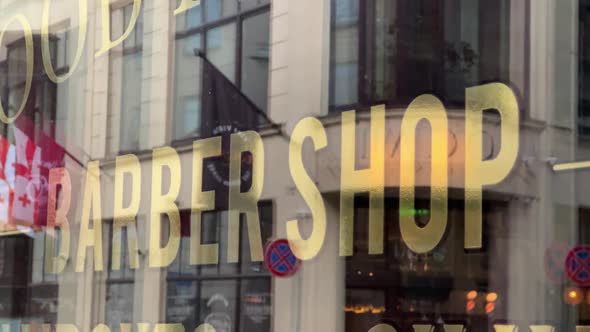 Barbershop Sign on Window with European City Street in Reflection