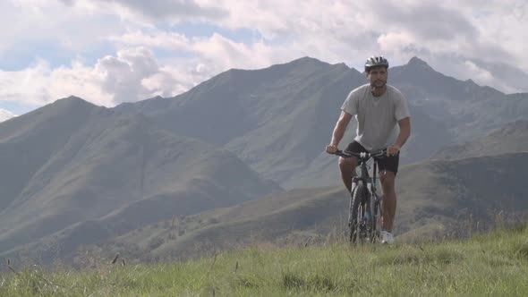 Young Athletic Man in Summer Day is Cycling Outdoor on Mountain with His Mountain Bike Slow Motion