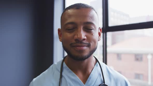 Portrait of mixed race male doctor looking at camera and smiling