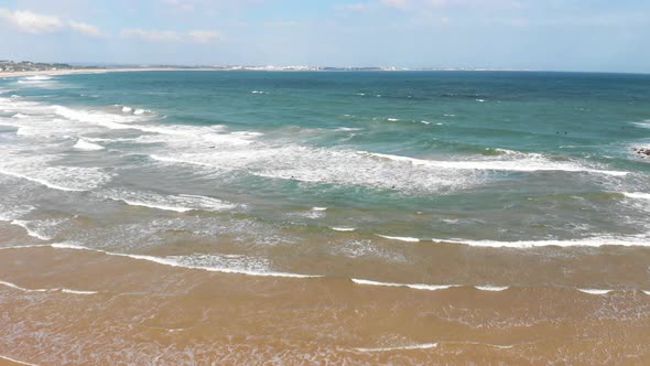 Waves softly coming ashore in Lagos, Algarve, Portugal - Aerial tilt down low angle shot