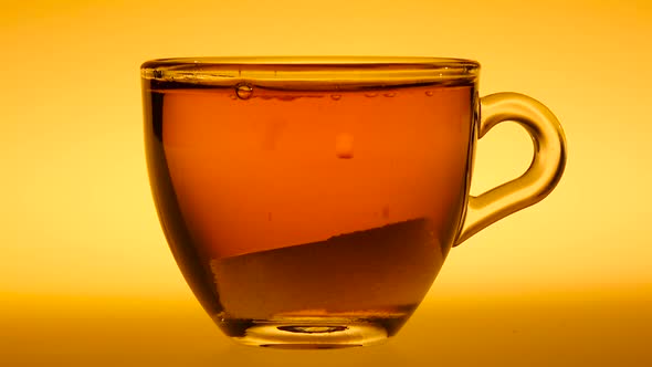 Two Pieces of Sugar Falling in Cup of Black Tea