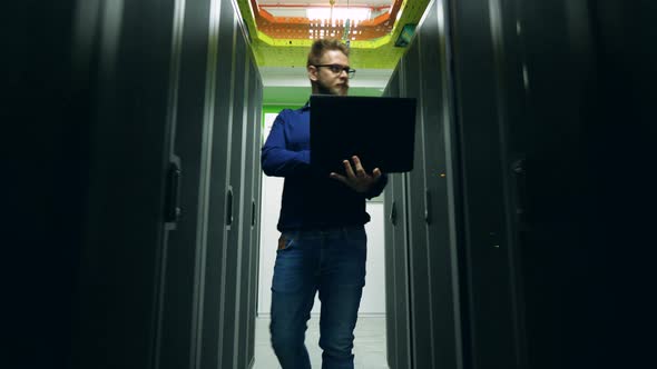 Computer Engineer Is Walking Along the Datacenter